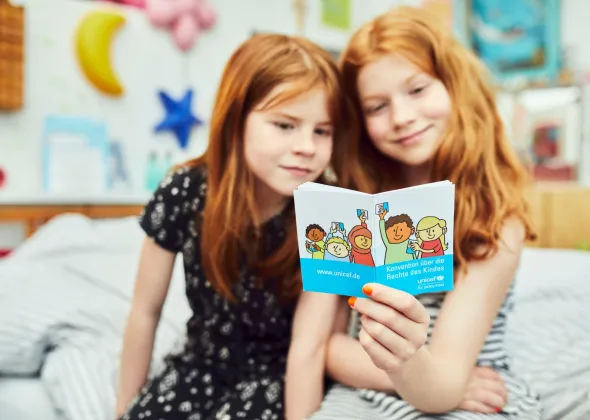 Children reading in the German Version of the Convention on the Rights of the Child. The photo was produced in the context of the campaign of the German Committee for UNICEF "Children's Rights into the Basic Law / Kinderrechte ins Grundgesetz".
