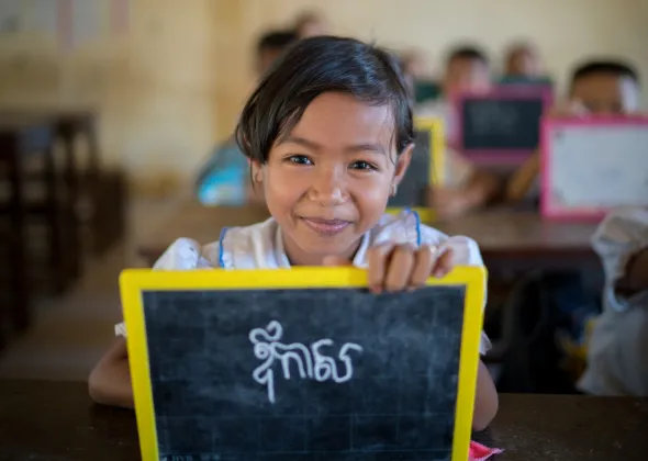 A girl shows her khmer writing on a personal chalk board at Kampong Thmar Primary School, Kang Sao village, Santok district, Kampong Thom commune, Kampong Thom province on July 4, 2018.