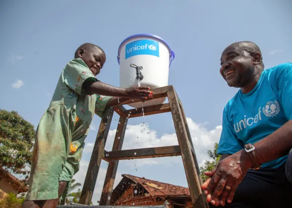 On 13 August 2018, Jean Marie Bofio, UNICEF’s WASH Officer, talks with a girl as she washes her hands in order to prevent the spread of Ebola near Mangina, North Kivu, the Democratic Republic of the Congo (DRC). “Children and women are among the first victims of the Ebola outbreak in the country. But there is hope and everything is done to stop Ebola. Water and sanitation are critical in this fight because hygiene is the best way to prevent the spread of the this deadly disease,” says Jean Marie Bofio.
