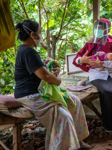 Nutritionist Dessy Sandra Dewi provides nutrition counseling to Iksan Driyana for her one-year old son Hasyim during a home visit in Paseban Village in Klaten, Central Java, Indonesia. ©