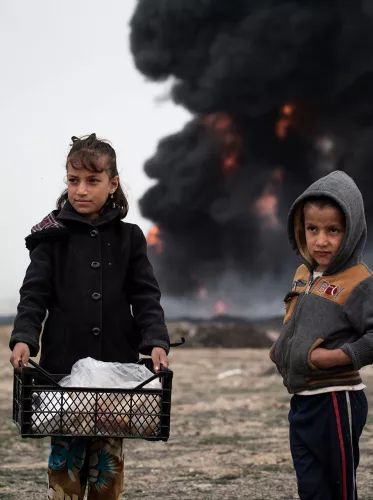 Irak 2017 - Kinderen brengen voedsel naar brandweerlieden die olieputten proberen te blussen die door ISIS-leden in brand zijn gestoken
